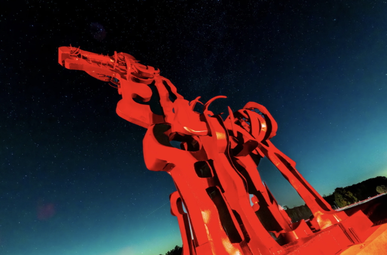 Photo of sculpture of horse, illuminated with red lights.