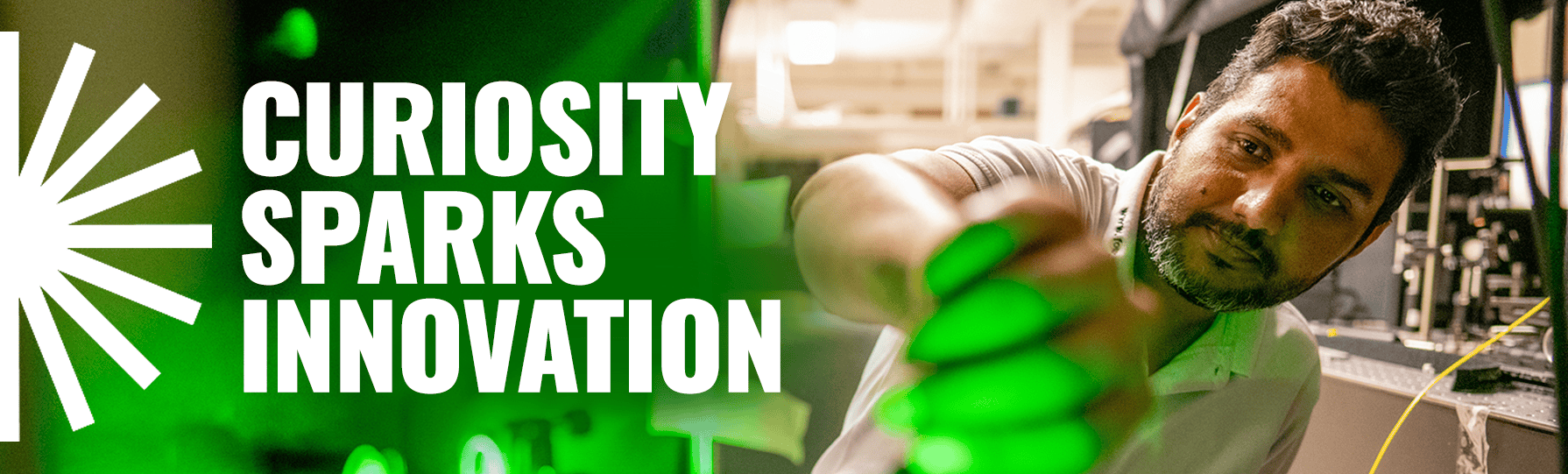 Curiosity Sparks Innovation banner with a man working in a lab