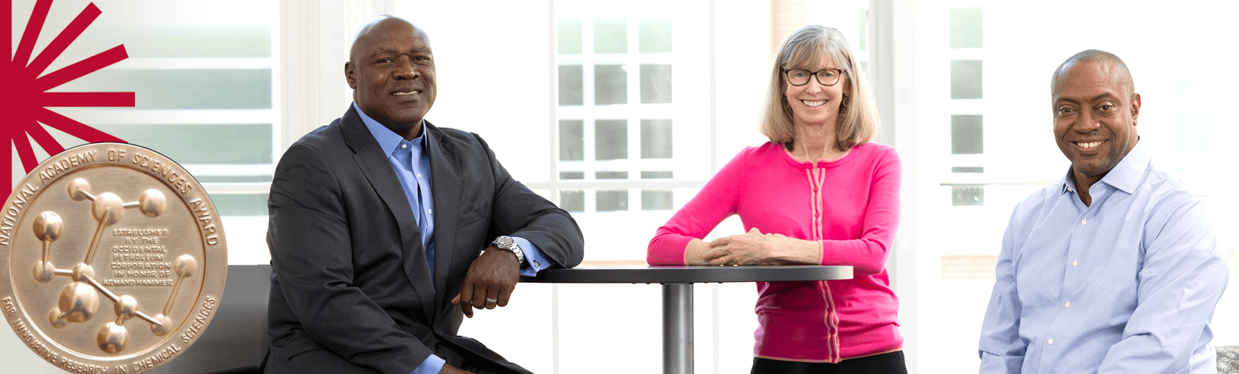 Three professors seated and smiling at the camera