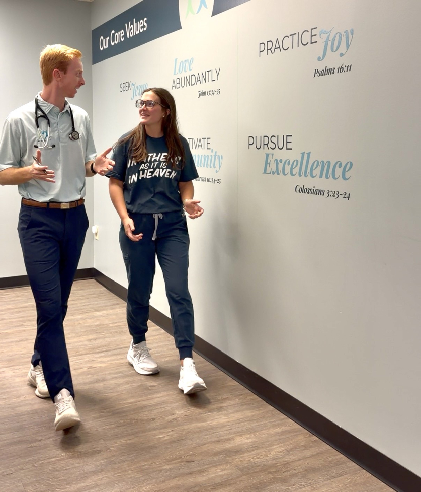 Cole Phillips walking and talking with colleague