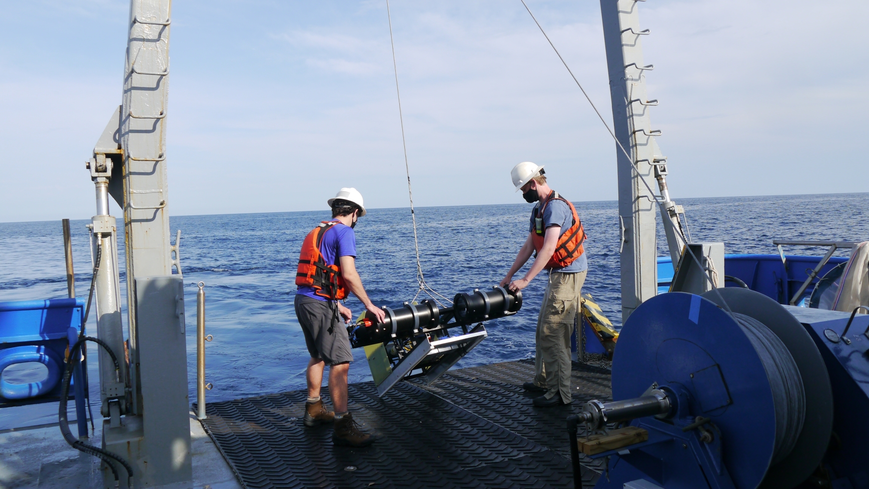 photo of two men on deck pof ship, day