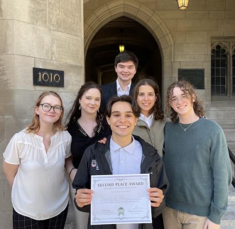 Students who placed second in the 2025 Ethics Bowl. They are all smiling at the camera and holding their award.