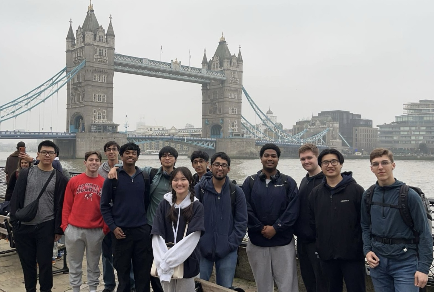 Students in front of river and bridge