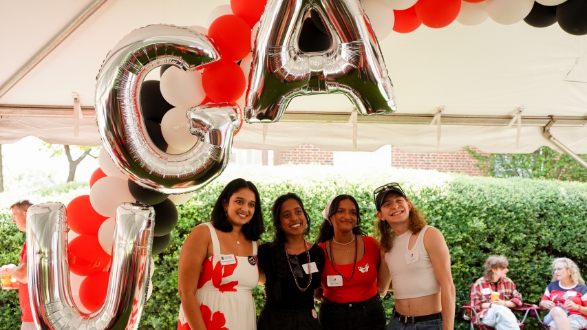 photo of four people with balloon letters