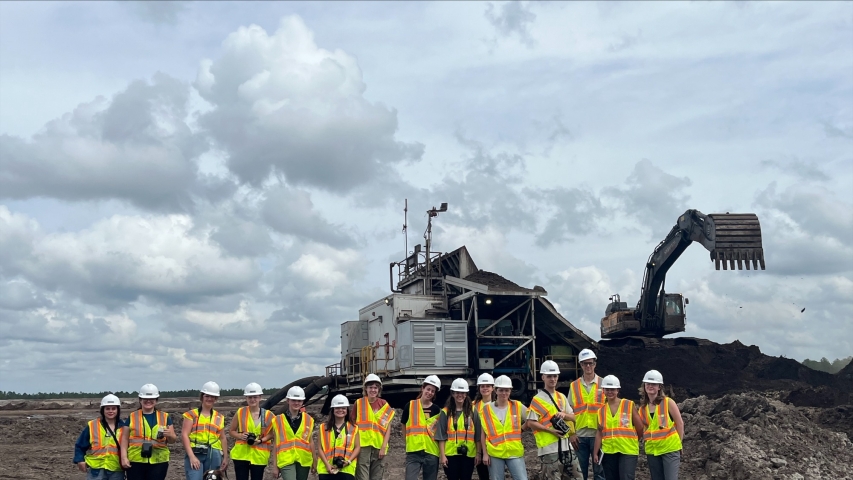 photo of people with backhoe in background, day