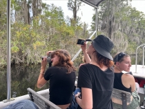 photo of people on boat in swamp