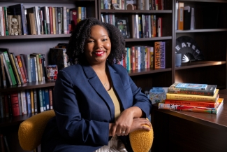 photo of woman in office, seated with books