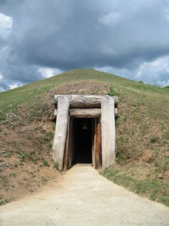 photo of mound lodge entrance, with grass and cloudy skies