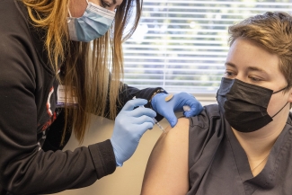 photo of nurse administering vaccination to woman