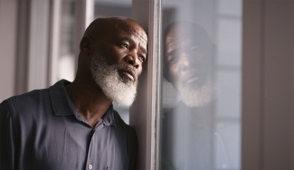 photo of man leaning against window 