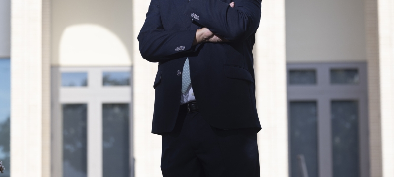 photo of man in front of building, day