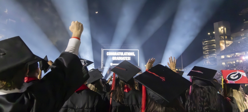 photo of people in caps and gowns, light beams