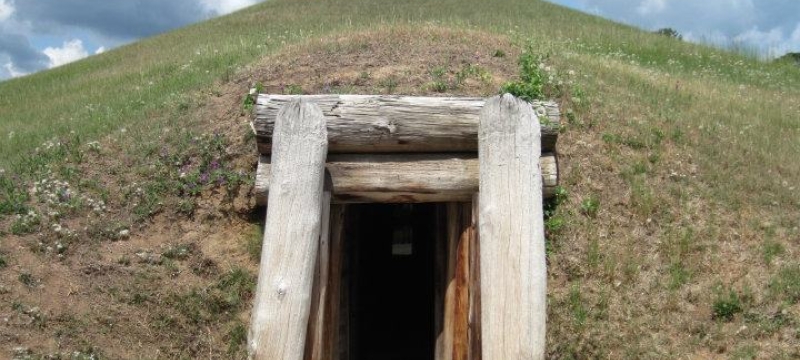 photo of mound lodge entrance, with grass and cloudy skies