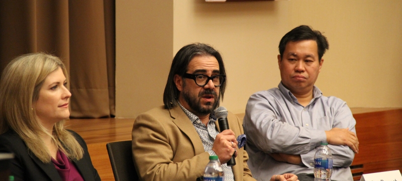 photo of three people, one holding microphone