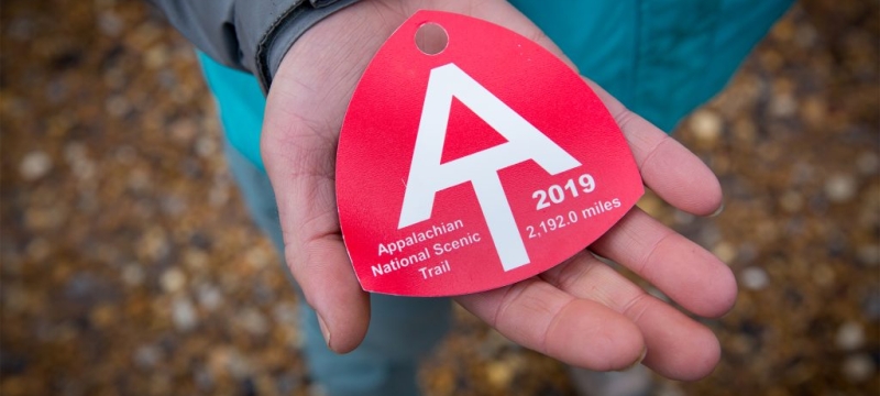 photo of person holding a red baggage tag