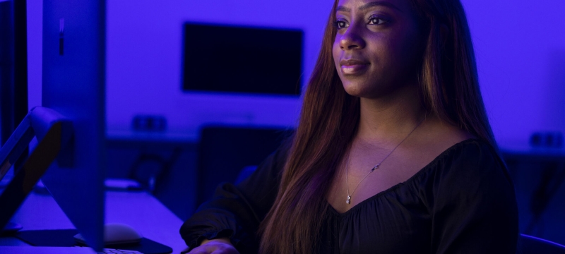 photo of woman at computer, blue tint background