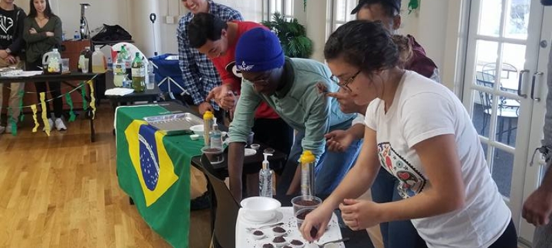 photo of students with table, flag and food