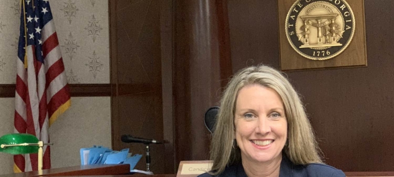 photo of woman, wait flag and state seal in background