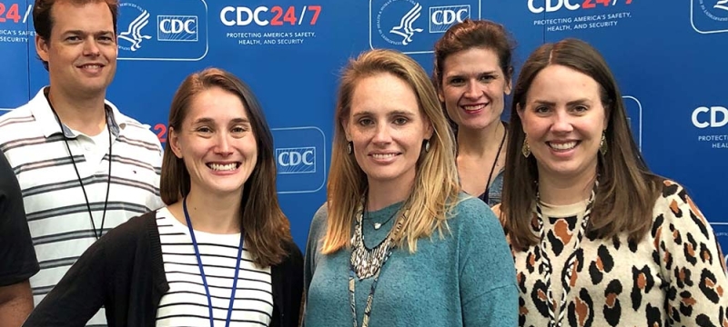 photo of five people with blue backdrop and text