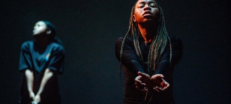 photo of two women on stage with their arms held together at the wrist