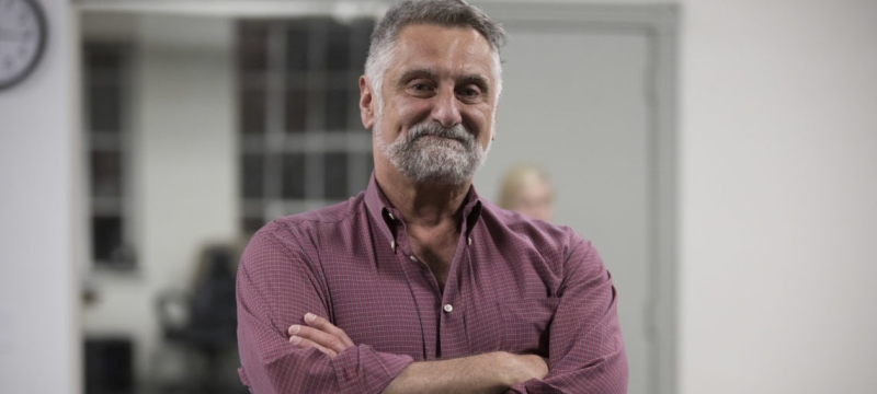 Photo of man indoors, arms folded