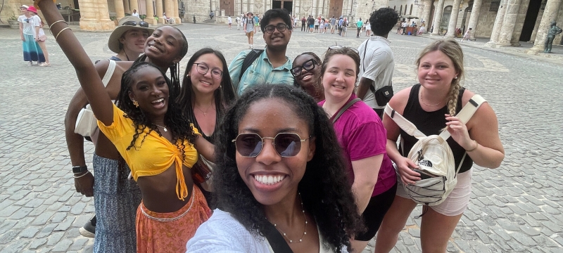 photo of group of people, classical architecture in background, day