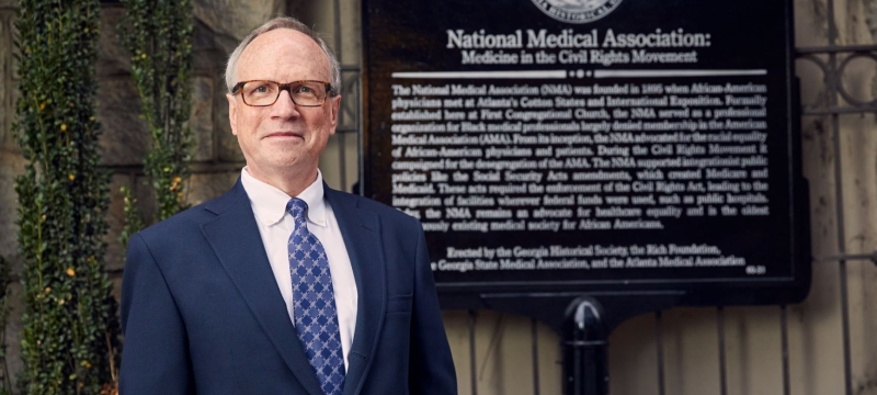 photo of man in front of historical marker
