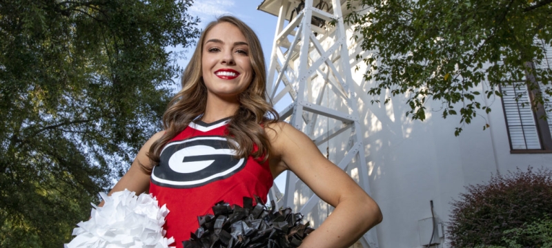 photo of cheerleader in front of the chapel bell