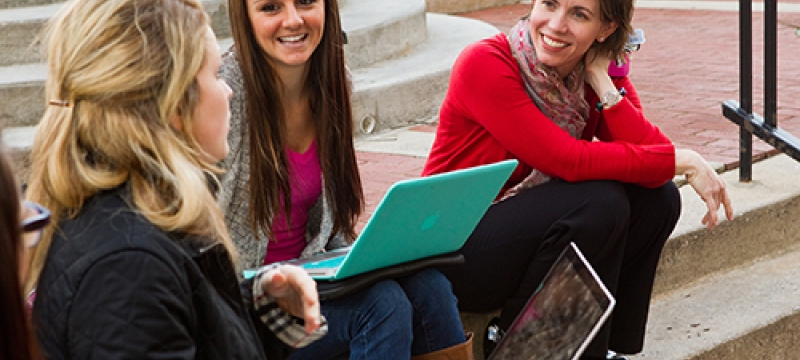 students on steps with computer