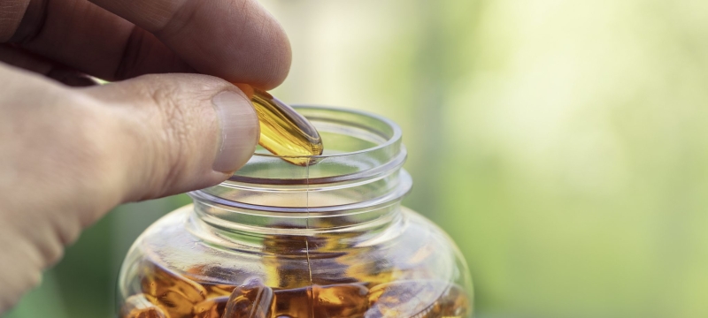 photo of hand with vitamins and bottle