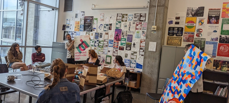 photo of people in discussion space, with images, notes and table