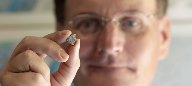 photo of man holding rock in foreground