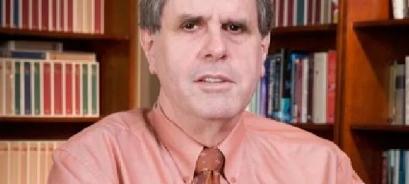 photo of man with books in background