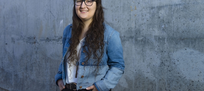 photo of woman standing against concrete wall
