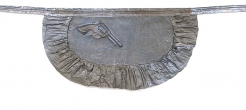 metal sculpture of apron with pistol