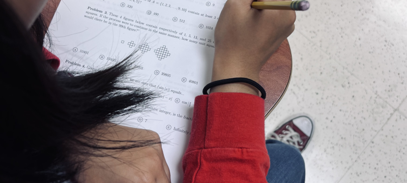 photo of person working match problems on paper with pencil