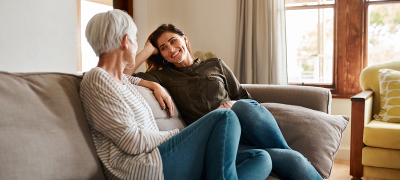 photo of two women talking on a couch