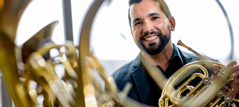 photo reflection of man with horn instrument