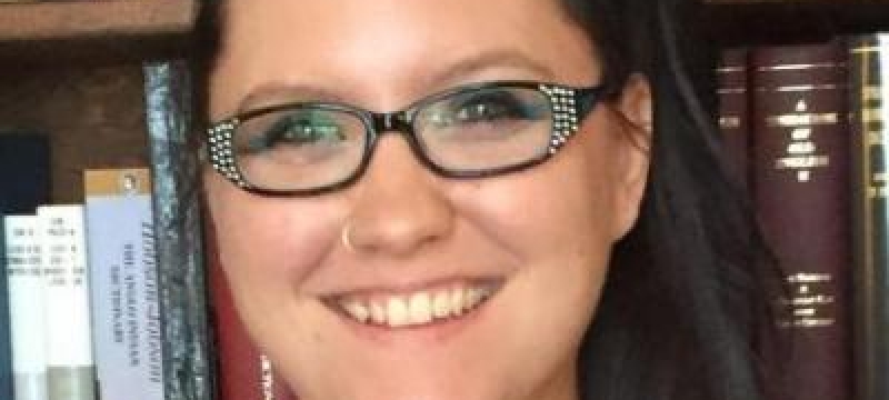 photo of woman, bookshelves in background