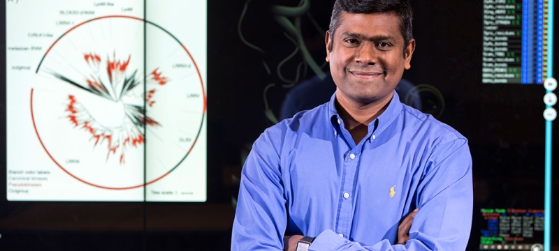 photo of man in front of computer screen projection