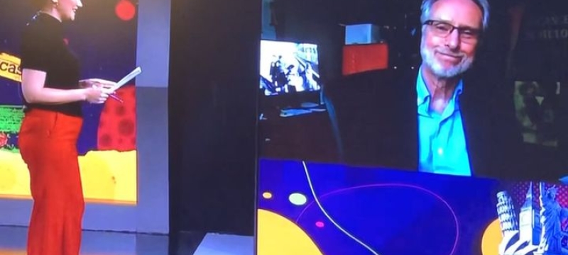 photo of woman interview man on screen in studio