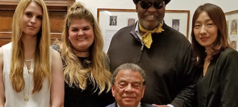 four people with man seated in gallery