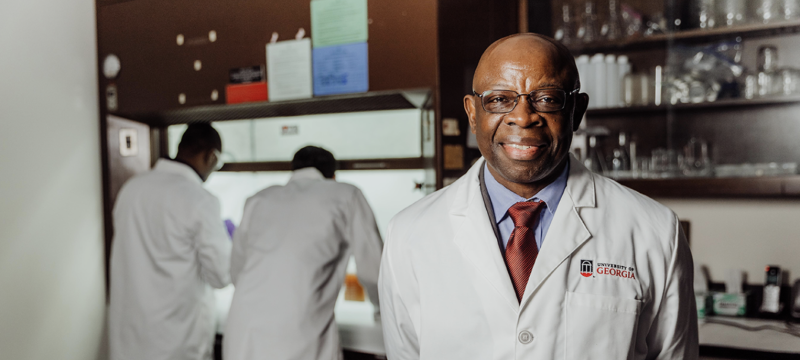 photo of man in lab, with two people in background