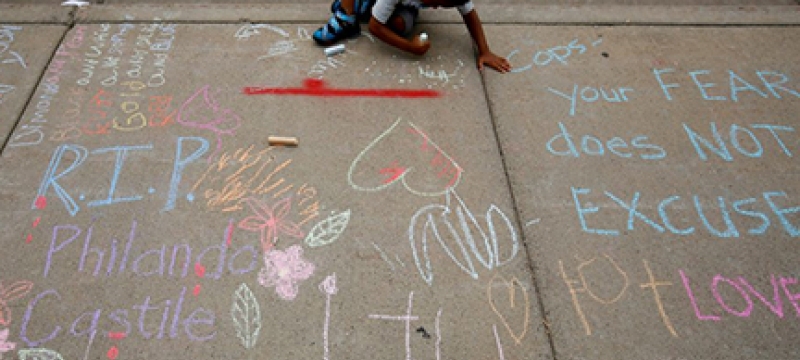 little boy drawing on a sidewalk