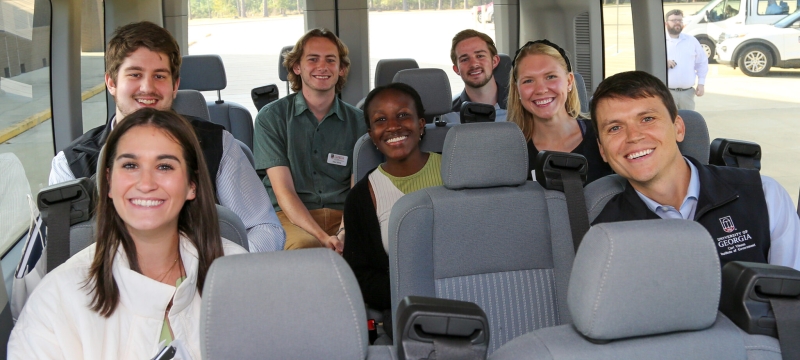 photo off seven smiling students inside a van