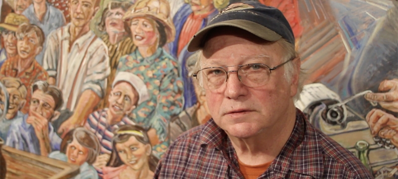 photo of man in front of mural