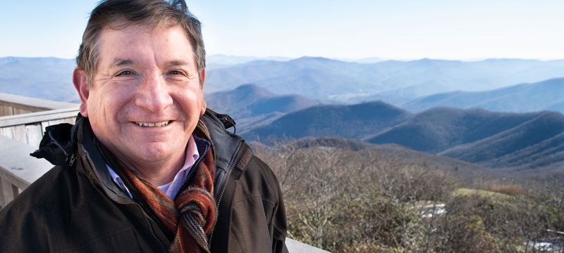 photo of man with mountains in background