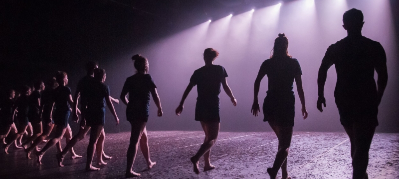 line of dancers on stage, with lights - photo from upstage