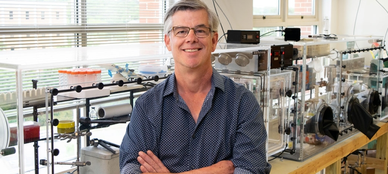 photo of man in research lab, arms folded