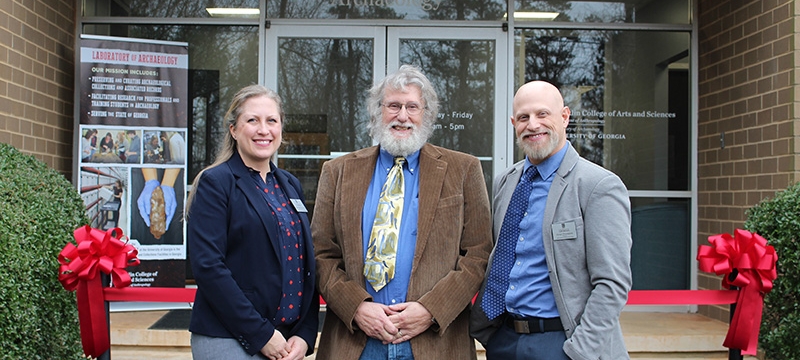 photo of woman and two men in front of building